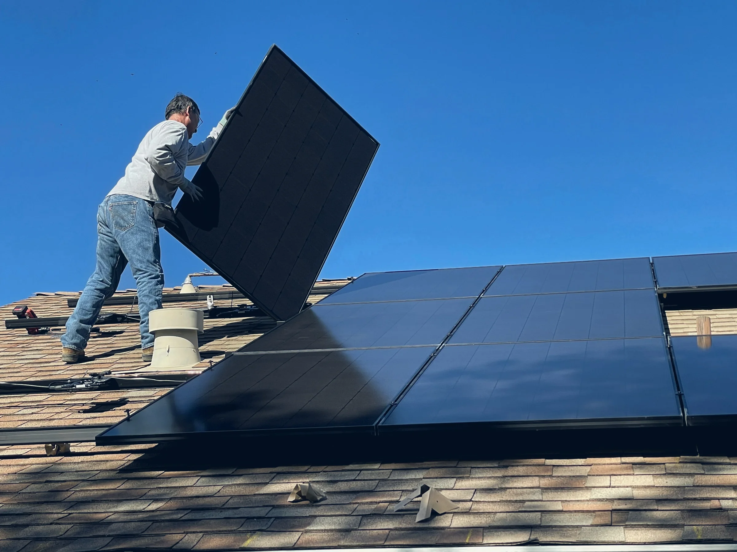 Instalador a montar um painel solar num telhado