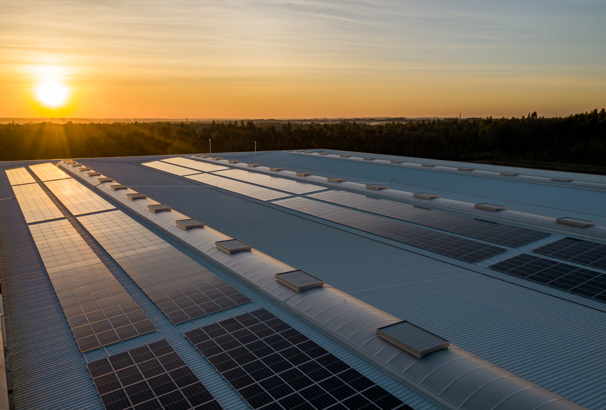 Painéis solares na cobertura de um armazém ao pôr do sol